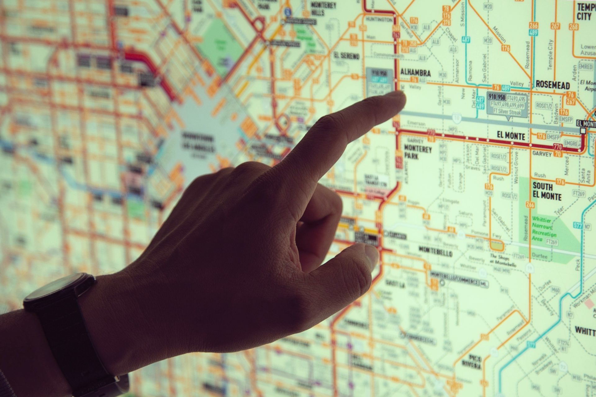 Hand pointing to a location on a map screen